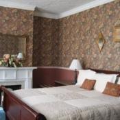 Guest room Guest room, cherry bed frame, brown floral wall paper, white fire place